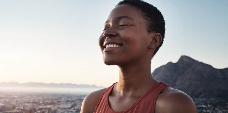 woman smiling while standing outdoors