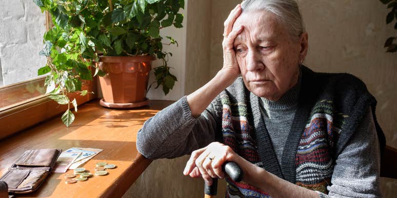 broke and upset woman looking at money in her home