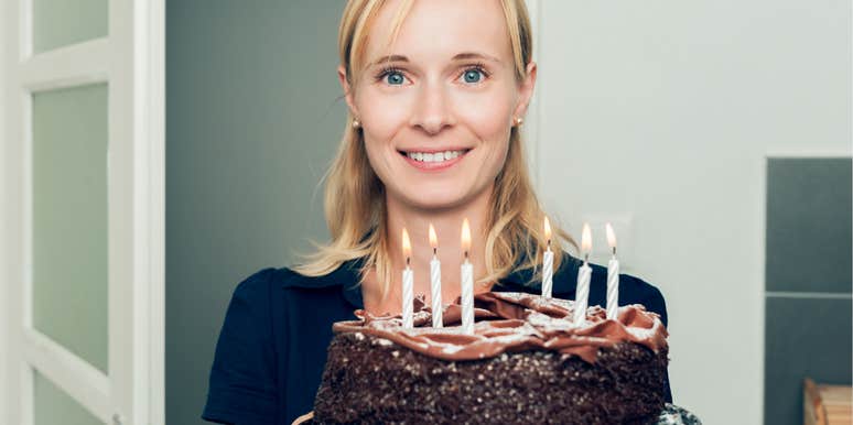 Girlfriend holding the birthday cake she made that her boyfriend didn't like