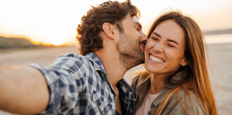 couple happily kissing and smiling meant to be together