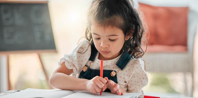 little girl struggling to hold a pencil