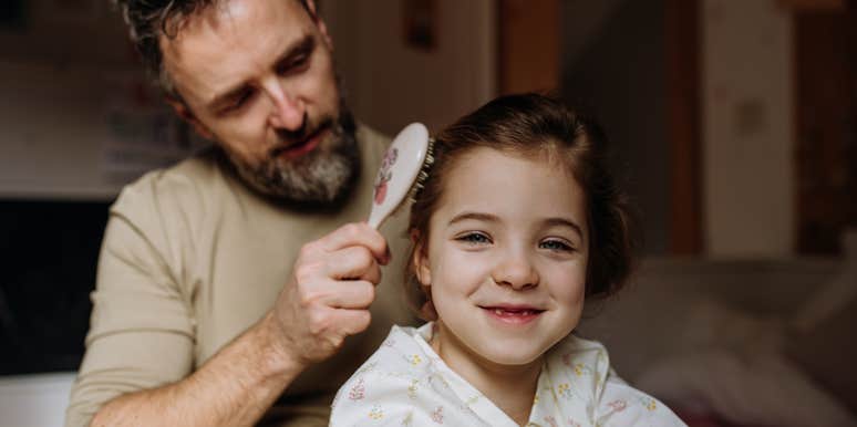 single dad brushing his daughter's hair