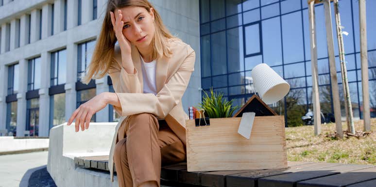 upset employee sitting outside of office after getting fired