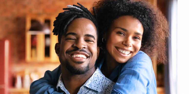 Happy couple smiling and hugging, illustrating simple habits of couples whose love actually lasts.