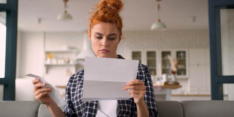 single woman worried about money looking at bill and receipt