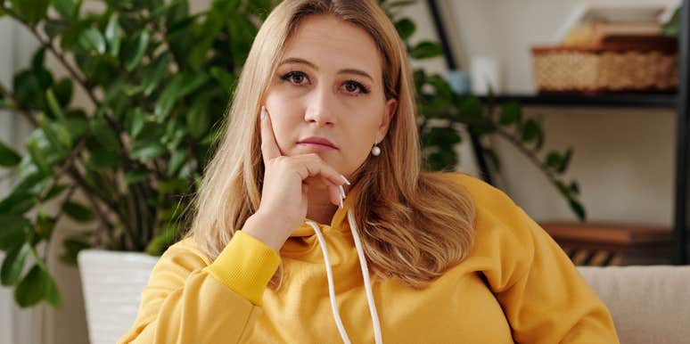 serious woman sitting alone on her couch