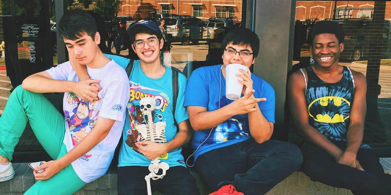 Four men sitting together on a platform, representing the wholesome trend that’s popular with Gen-Z right now