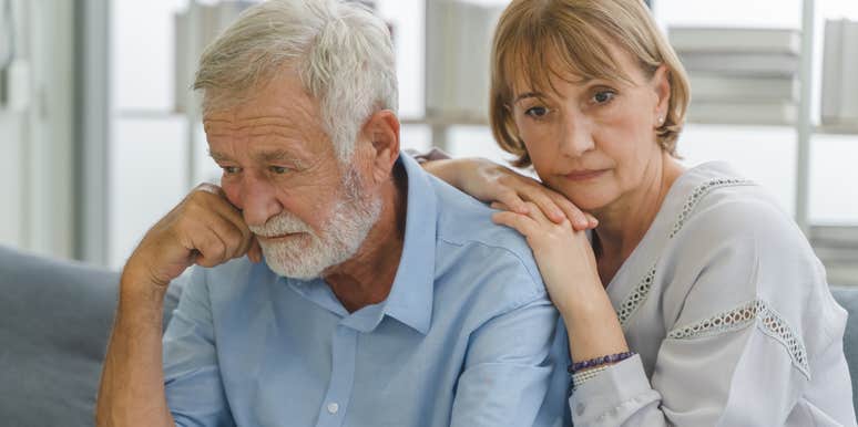 unhappy older couple sitting at home