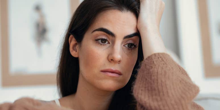 exhausted woman sitting at home thinking