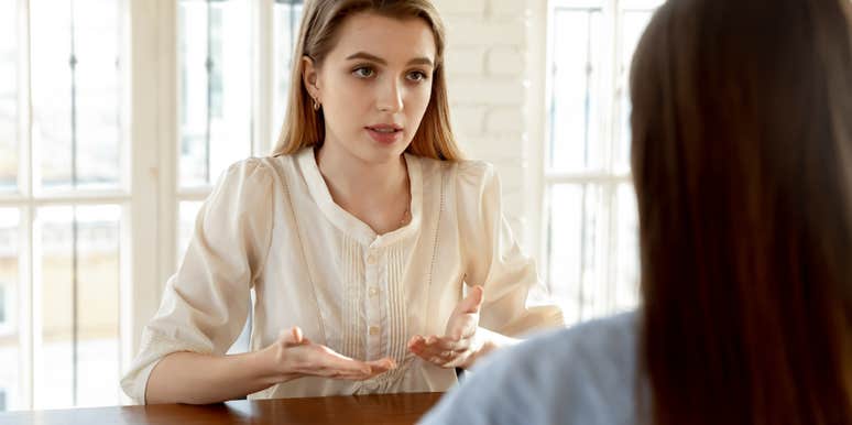 woman having conversation with friend sitting across from her