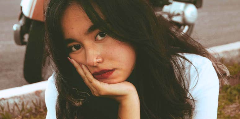 Sad woman resting her hand under her chin, illustrating signs it may be time to end a relationship with a problematic partner