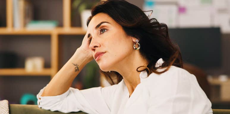 Lonely woman sitting on sofa in quiet home, deep in anxious reflection, wondering if she married the right person — emotional insight into midlife relationship doubt.
