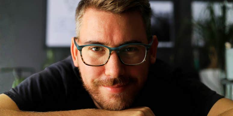 Warm confident man smiling indoors showing the art of being a decent husband.