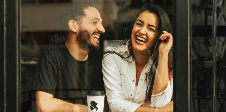 Attentive man listening as a woman opens up laughing showing the art of making conversation and questions that help her share more