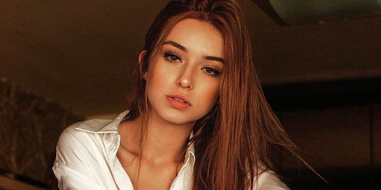 Seductive woman with long hair wearing a blouse, illustrating the simple habits and confidence of naturally seductive people.