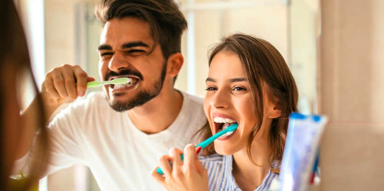 Couple brushing teeth together in the mirror, illustrating relatable everyday moments for people who’ve been in long-term relationships