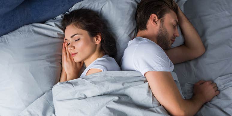 couple sleeping in bed facing away from each other