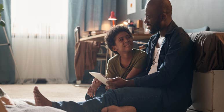 dad talking to son sitting on the floor