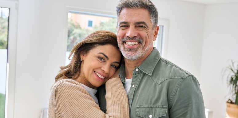 middle aged couple smiling hugging each other at home