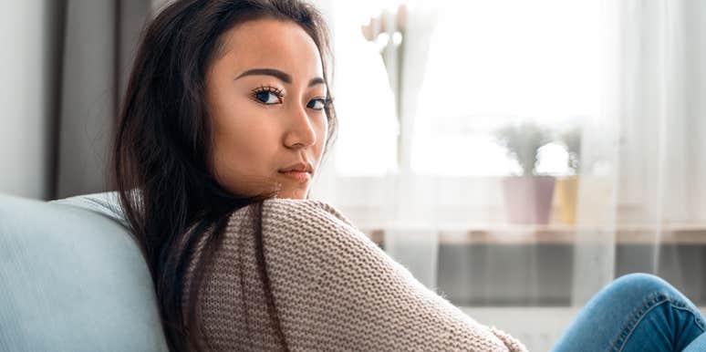 stressed out woman sitting on her couch at home
