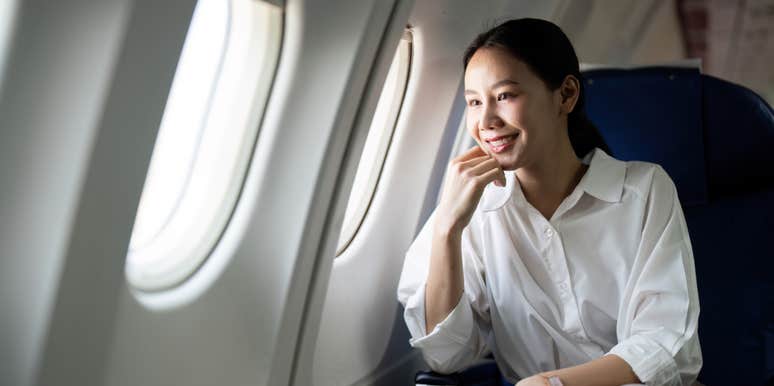 woman sitting next to window on plane