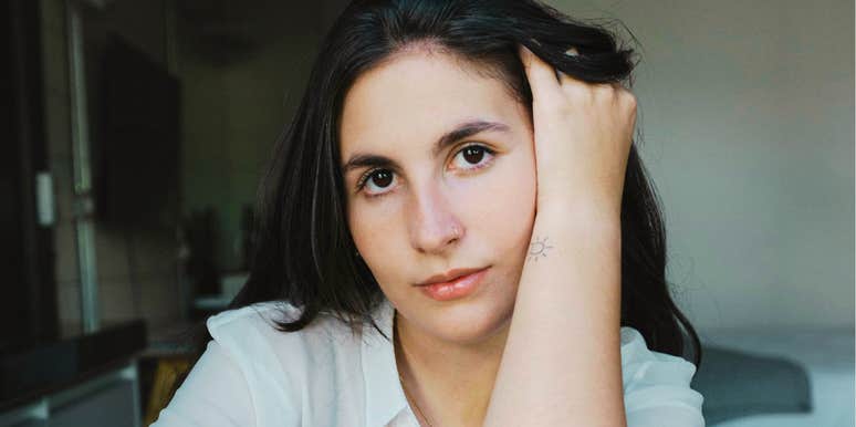 Heartbroken person with hand in their hair staring ahead showing the key emotional ingredient people lack when they can’t shake a toxic ex.