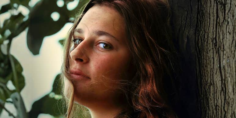 Uneasy emotionally unstable woman peering over her shoulder showing early signs people notice in unstable relationships./