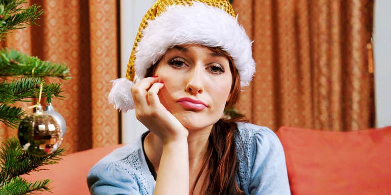 Sad woman wearing a Santa hat at Christmas, reflecting the habits that cause relationships to fall apart during the holidays.