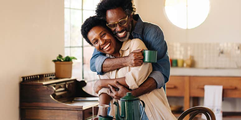 husband holding his wife in a tight hug at the breakfast table