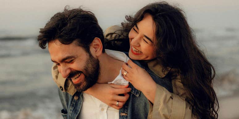 Wife sharing a warm moment with her smiling husband showing the simple tricks that make husbands much happier according to a clinical psychologist.