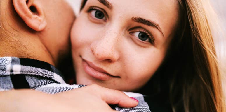 Focused woman with a couple embracing showing why people like who they like romantically and the evolutionary reasons behind attraction.