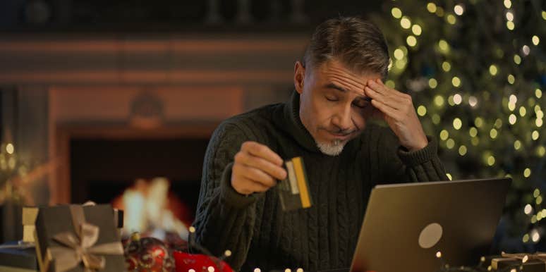 stressed man buying gifts for the holidays on his laptop holding credit card
