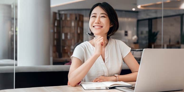 smiling young woman working on laptop at work