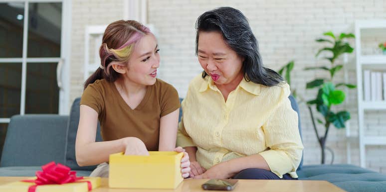 older woman giving teen girl gift