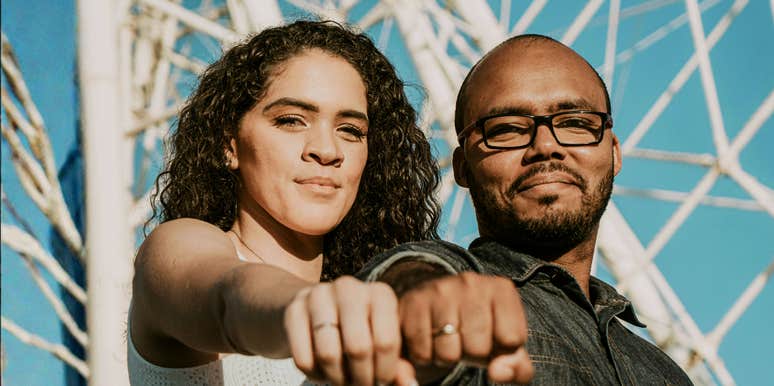 confident driven couple standing side by side with fists forward, symbolizing the simple signs you’ve found a high-achieving soulmate and are truly a power couple