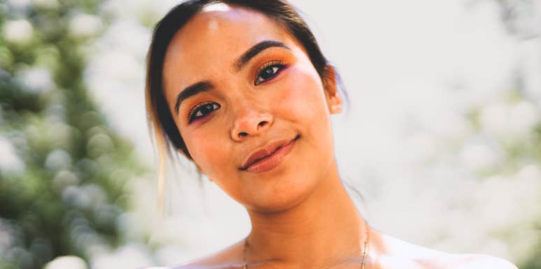 Woman’s face up close with a tired, gentle smile and emotionally drained eyes, reflecting the art of doing what you can when you’re completely spent