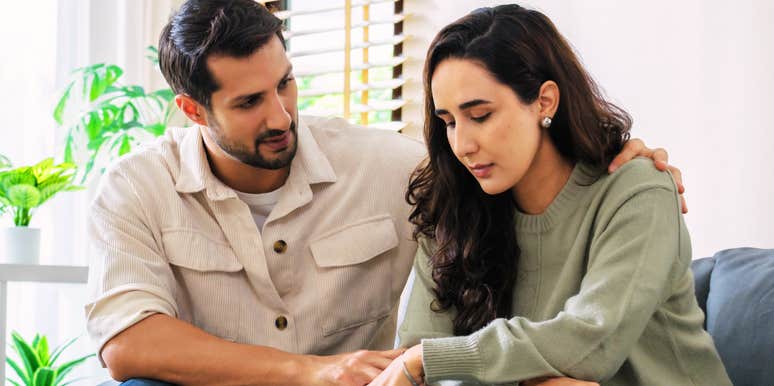 Couple sitting together at home during an emotional moment.