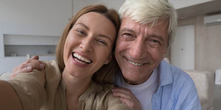 older father and grown adult daughter taking a selfie smiling