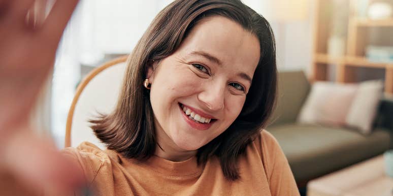 emotionally intelligent woman taking selfie and smiling