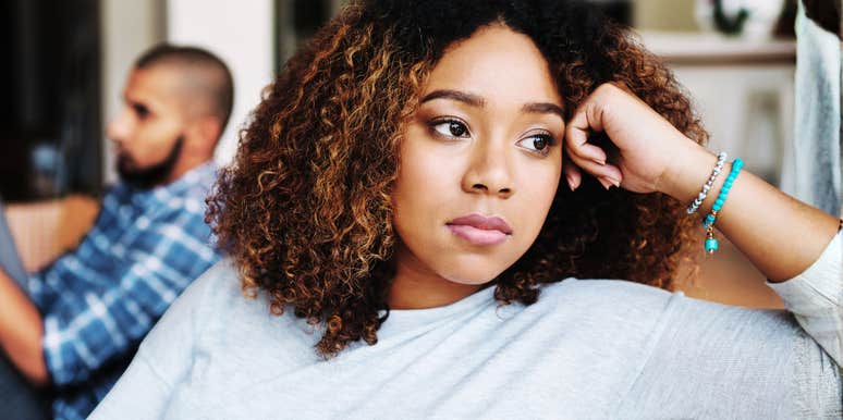 Worried woman sitting apart from her partner showing the habits you need to say goodbye to in your thirties and forties for a happy marriage.