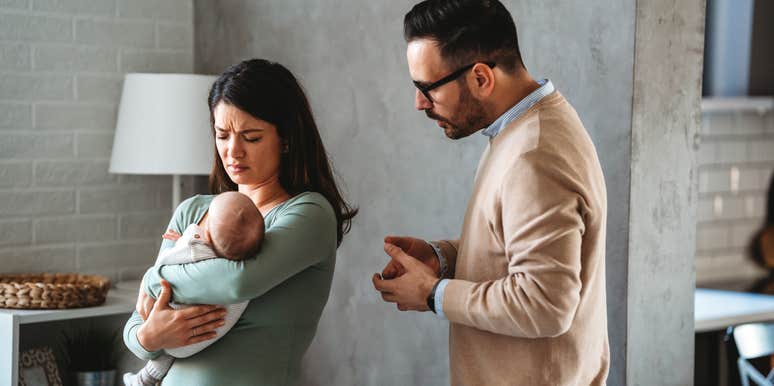 husband trying to comfort upset mom with newborn baby