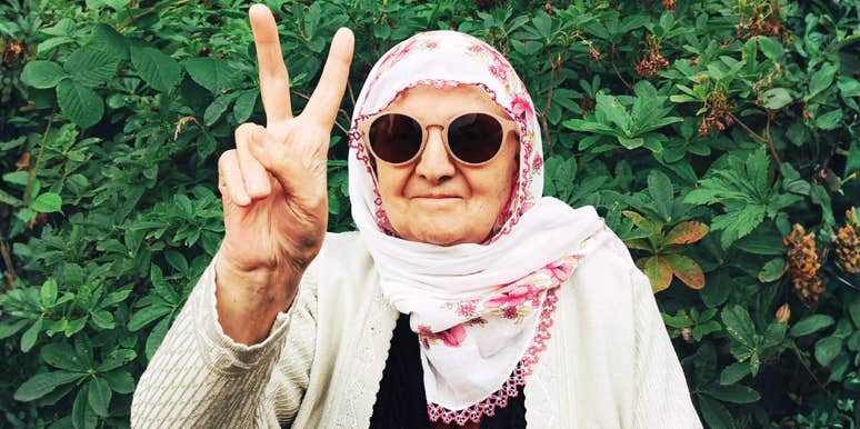 seventy-two-year-old mother wearing sunglasses and a floral scarf flashing a playful peace sign, capturing the bold moment she quit bacon and her forty-year marriage on the same day