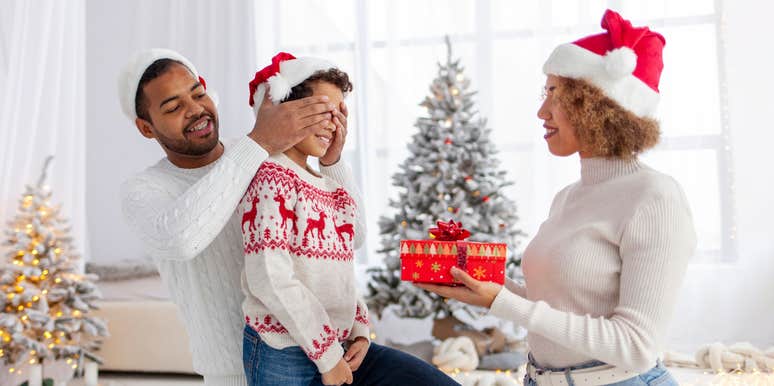 parents giving their kid a gift on Christmas