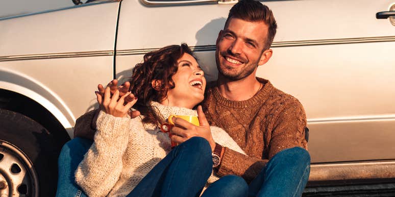 Young couple enjoying a sunset picnic by an old-fashioned car showing how people in their thirties love differently than those in their twenties.