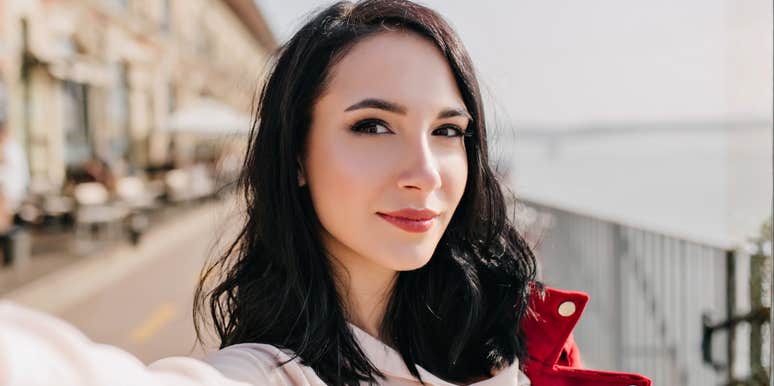 Woman standing near the water with a calm, confident expression, capturing the quiet moment when small daily habits begin to change the direction of your life.