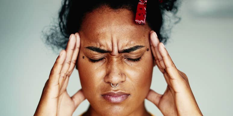 young woman feeling stressed out holding her head