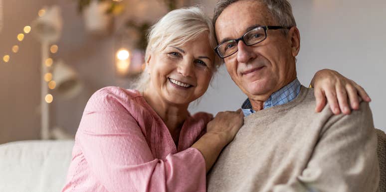 upper middle class older couple sitting comfortably in their home