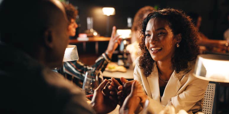 woman out to dinner and holding hands with partner at restaurant