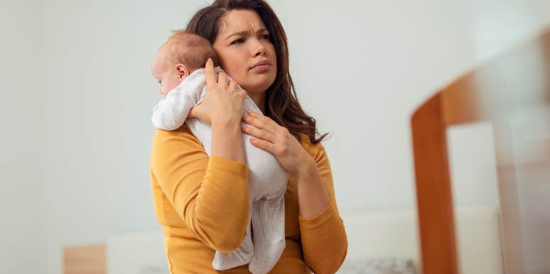 mom stressed about paying rent holding newborn baby