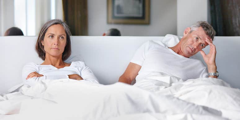 upset couple sitting in bed together